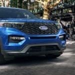 A blue 2021 Ford Explorer is on a city street after winning the 2021 Ford Explorer vs 2021 Jeep Grand Cherokee comparison.