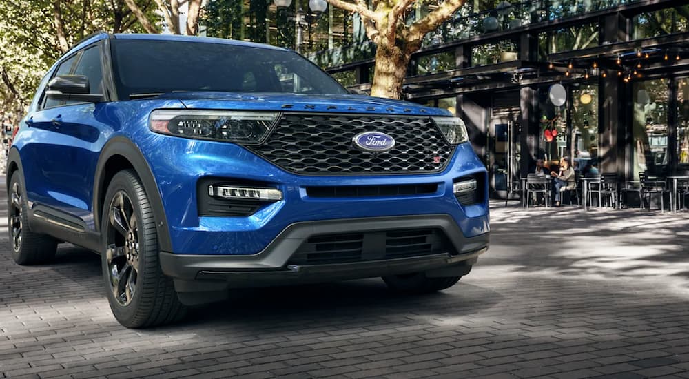 A blue 2021 Ford Explorer is on a city street after winning the 2021 Ford Explorer vs 2021 Jeep Grand Cherokee comparison.