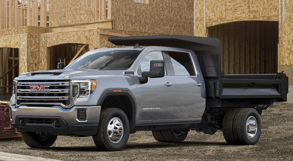 A grey 2021 Chevy 3500 Chassis Cab is parked in front of a house under construction.