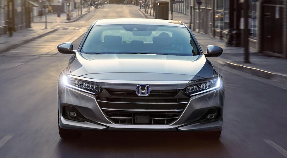 A popular 2021 Honda Hybrid, a silver 2021 Honda Accord Hybrid, is shown from the front on a city street.