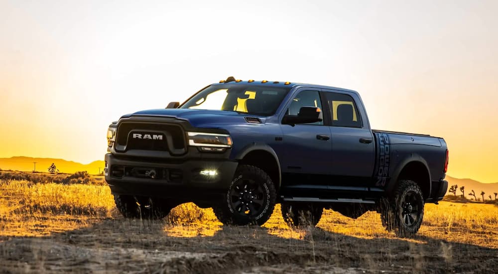A blue 2021 Ram 2500 Power Wagon is in front of a sunset.