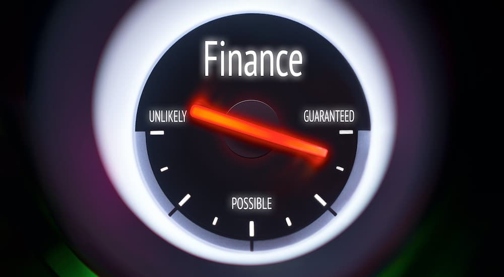 A close up shows a tachometer with financing labels on it.