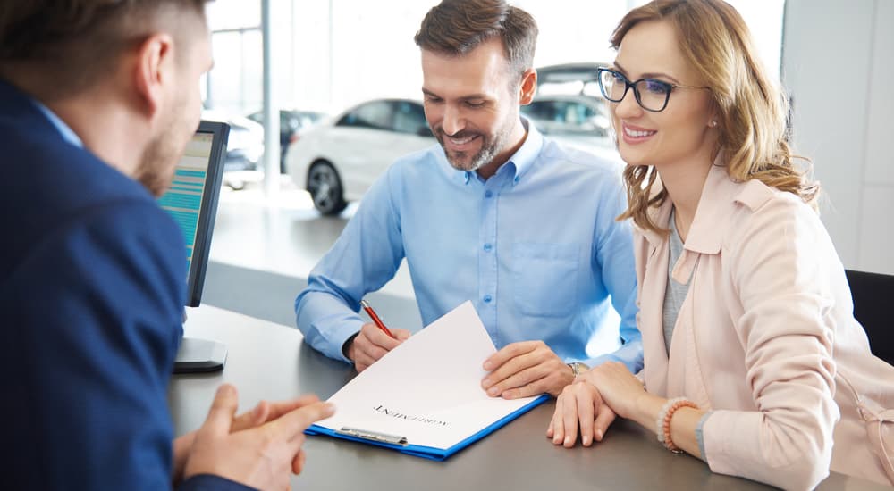 A couple is going over a contract at a dealership.
