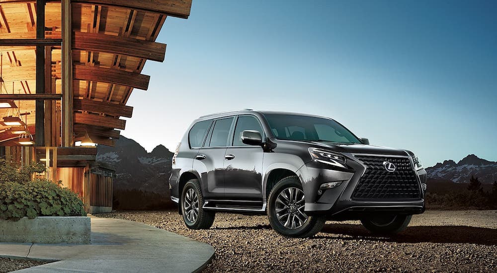 A gray 2021 Lexus GX is parked in front of a lodge.