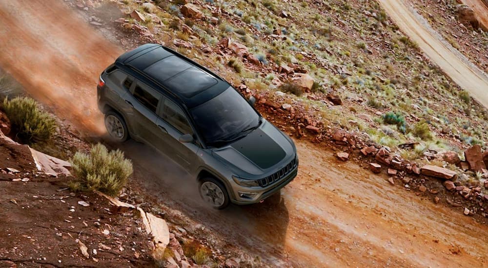 A grey 2019 used Jeep Compass is shown from above on a red dirt road.