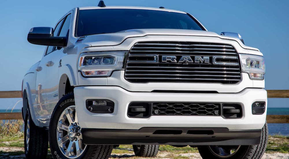 A white 2020 Ram 2500 is parked in front of an ocean.