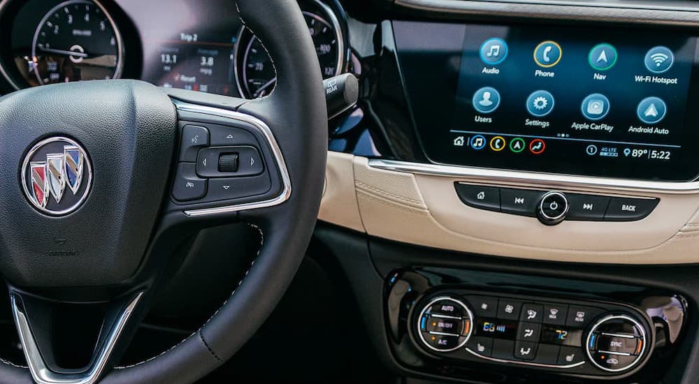A close up shows the steering wheel and infotainment screen in a 2021 Buick Encore GX.
