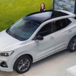 A white 2021 Buick Encore GX is shown from a high angle, parked in a driveway.