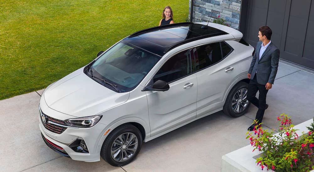 A white 2021 Buick Encore GX is shown from a high angle, parked in a driveway.