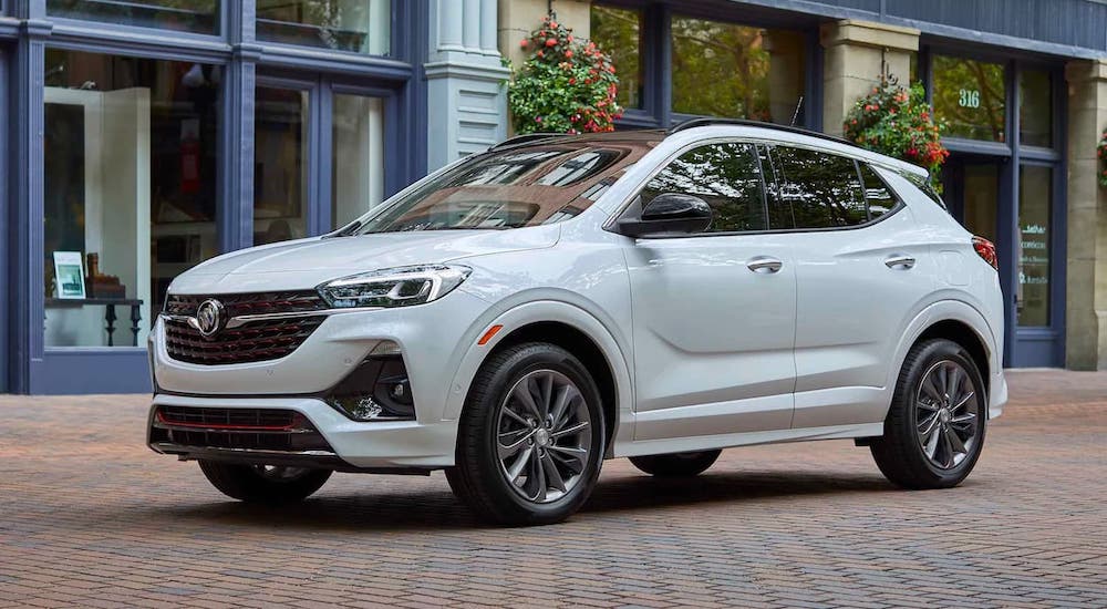 A white 2021 Buick Encore GX is parked on a cobblestone road.