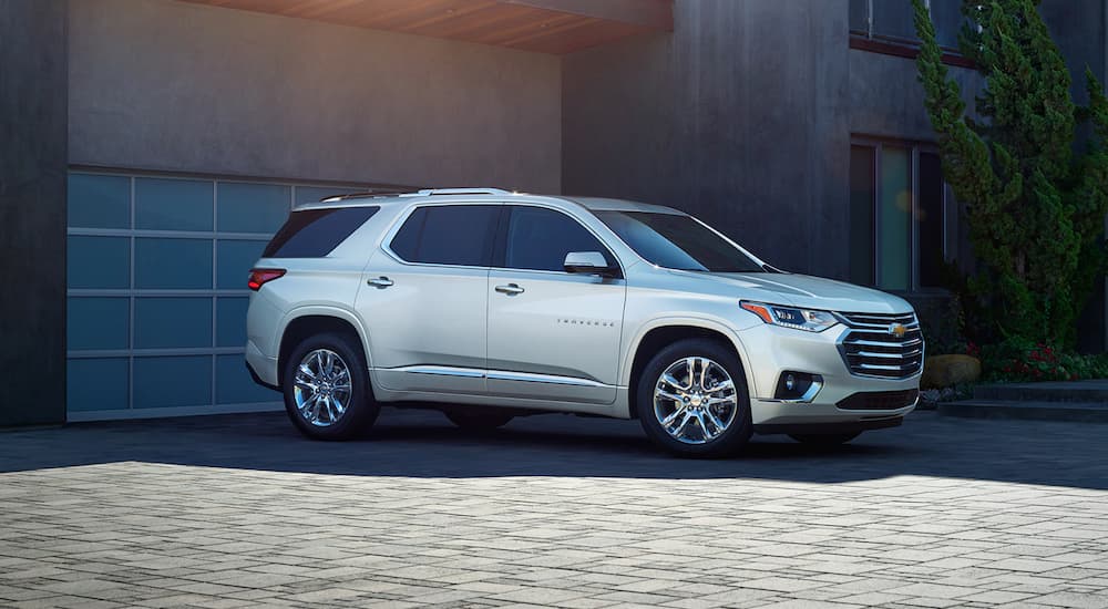 A silver 2021 Chevy Traverse is shown from the side parked on a paver driveway.