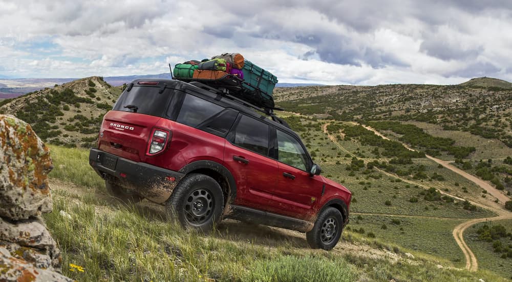 A red 2021 Ford Bronco Sport is off-roading on a dirt path downhill.