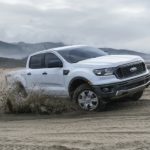 A white 2021 Ford Ranger is off-roading in sand.