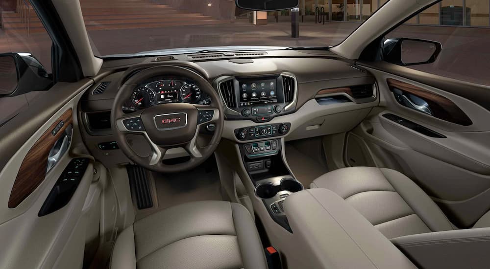 The gray and brown front seats and dash are shown from the rear seats in a 2021 GMC Terrain.