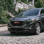 A gray 2021 GMC Terrain is shown parked on a brick roadway.