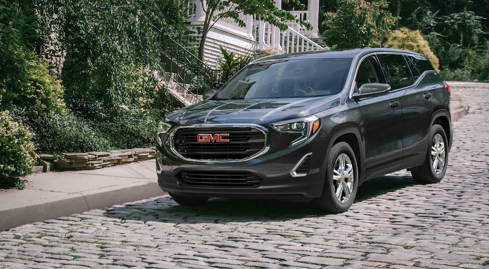 A gray 2021 GMC Terrain is shown parked on a brick roadway.