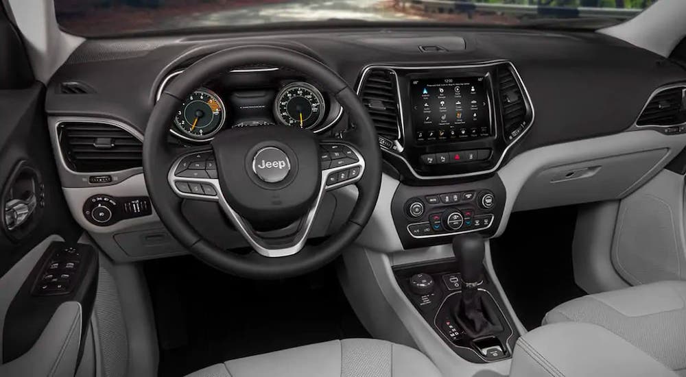 The gray and black dashboard and steering wheel are shown in a 2021 Jeep Cherokee.