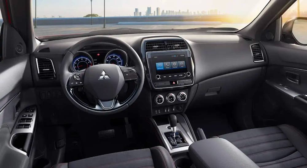 The black interior and dashboard are shown in a 2021 Mitsubishi Outlander Sport.