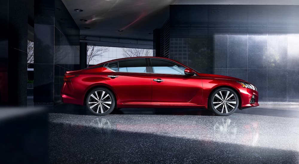 A red 2021 Nissan Altima is shown from the side parked in a granite hallway.