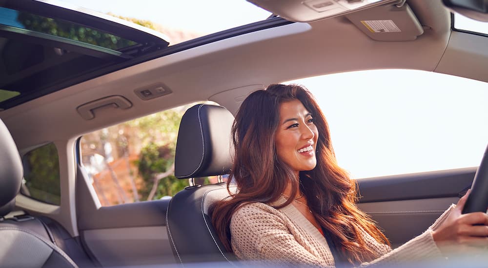 A woman is shown driving a 2022 Volkswagen Taos.