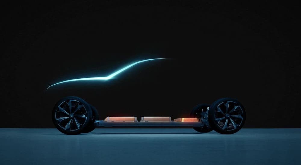 The silhouette of a Chevy EV is shown, these vehicles soon to be coming to a Chevy Dealer Near you.