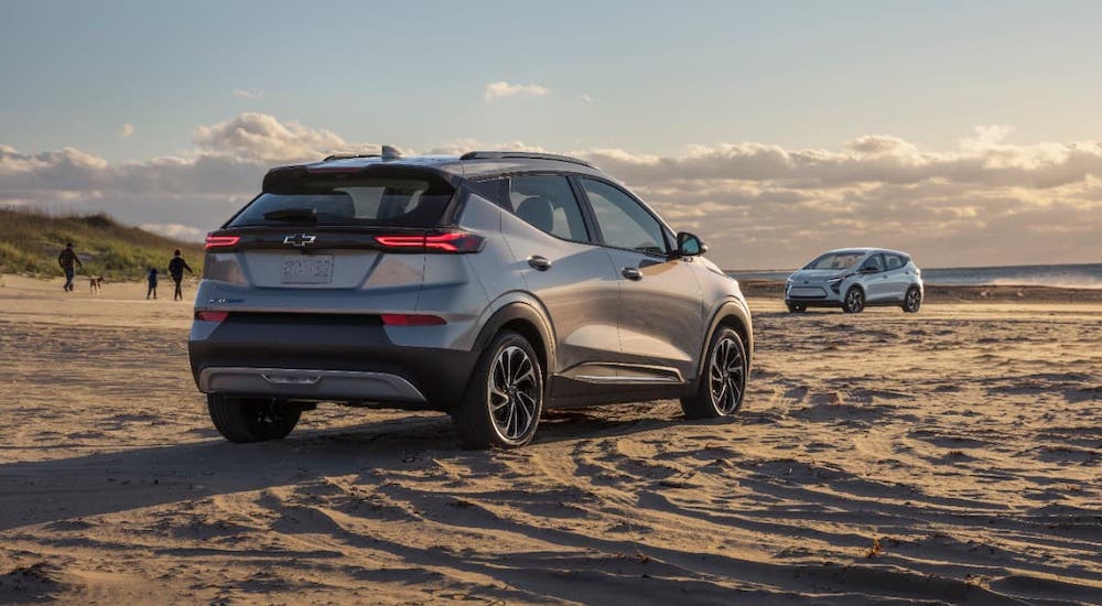 A silver 2022 Chevy Bolt EUV is parked on a beach and shown from a rear angle.