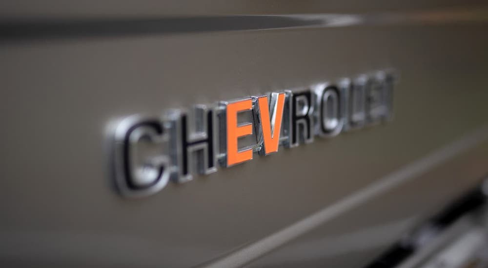 A closeup shows the badging on a gold SEMA 360 Blazer concept where the 'EV' in Chevrolet is orange.