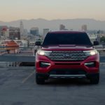 A red 2021 Ford Explorer is shown with a city in the background.