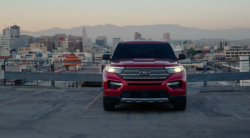 A red 2021 Ford Explorer is shown with a city in the background.