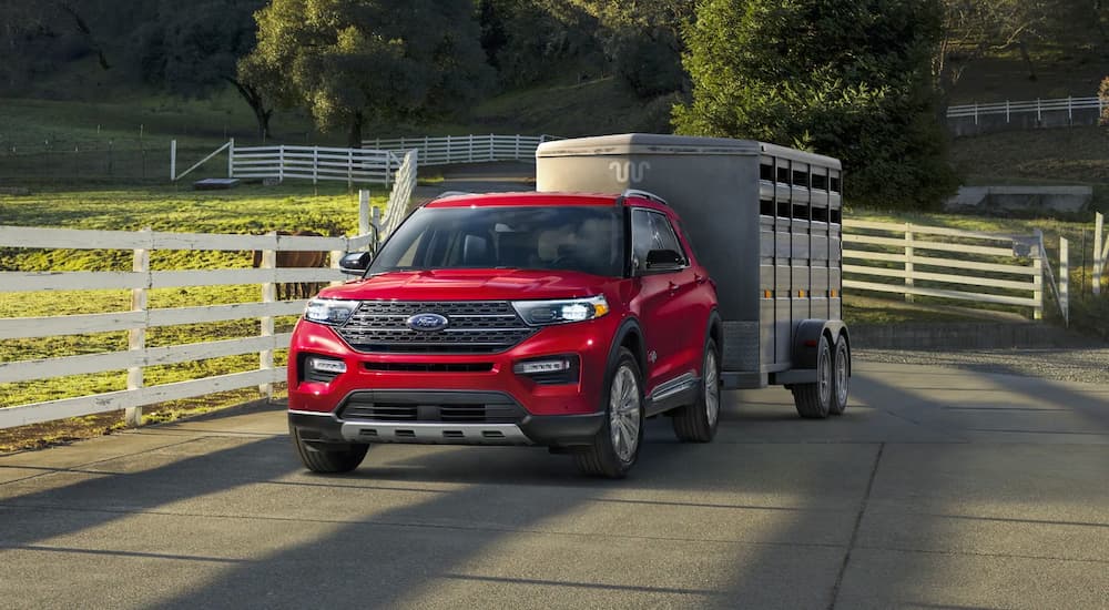 A red 2021 Ford Explorer is shown from the front towing a silver horse trailer.