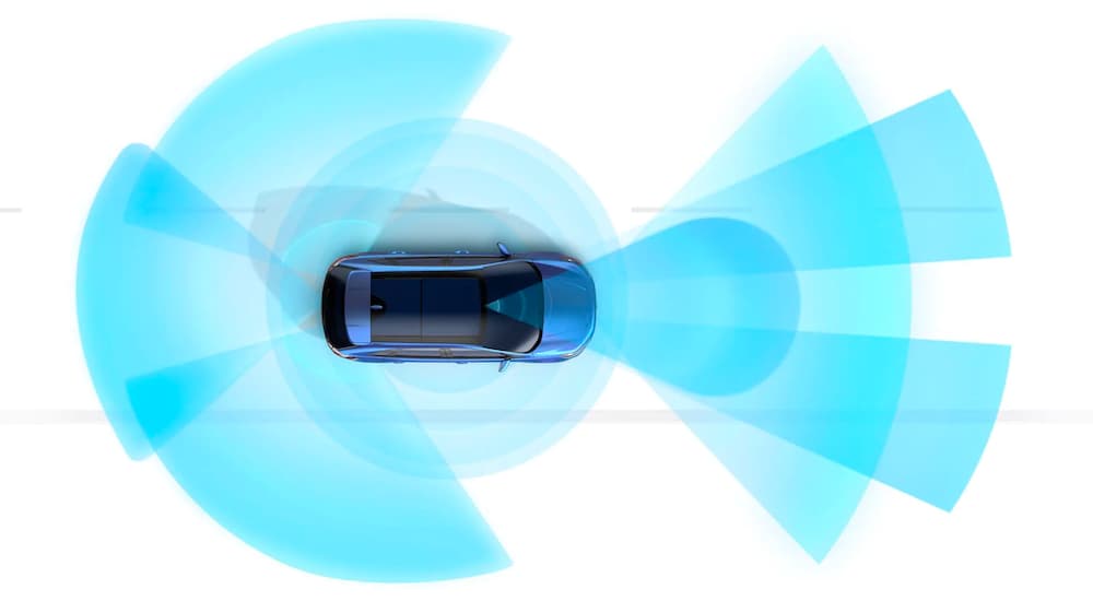 A blue SUV, from a Ford dealership, is shown from an aerial angle with front and rear simulated sensor lines.