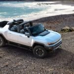 A white 2022 GMC Hummer EV is shown from a high angle parked on a beach.