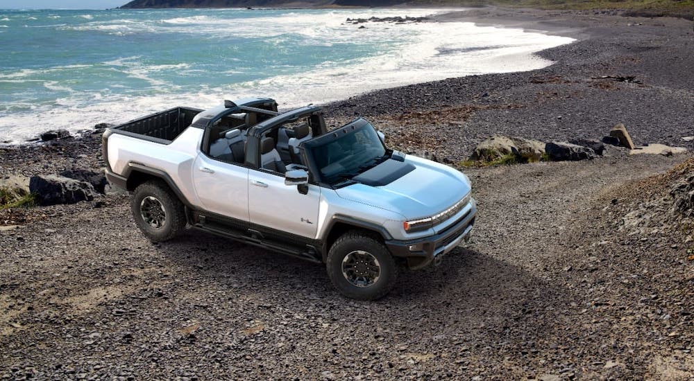 A white 2022 GMC Hummer EV is shown from a high angle parked on a beach.