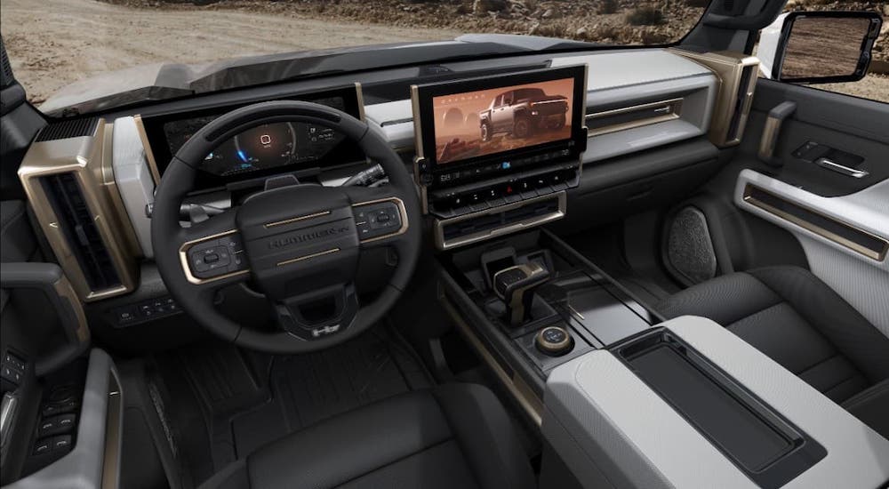 The black and gray interior and dash of a 2022 GMC Hummer EV are shown.