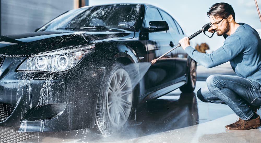 A man is shown pressure washing a vehicle, which is common if you are trying to sell your car.