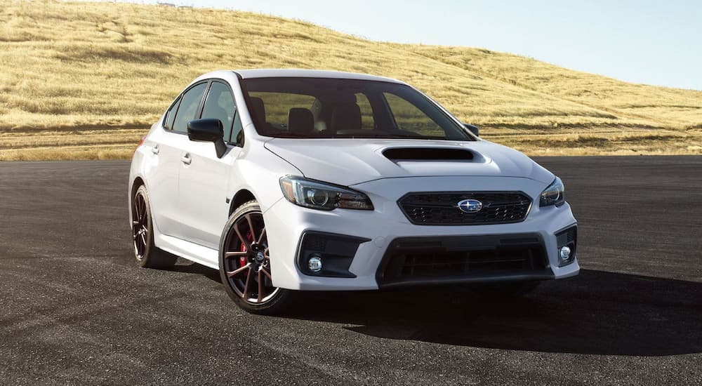 A white 2020 WRX Series.White from a Subaru dealer near me is parked on pavement in front of grass.
