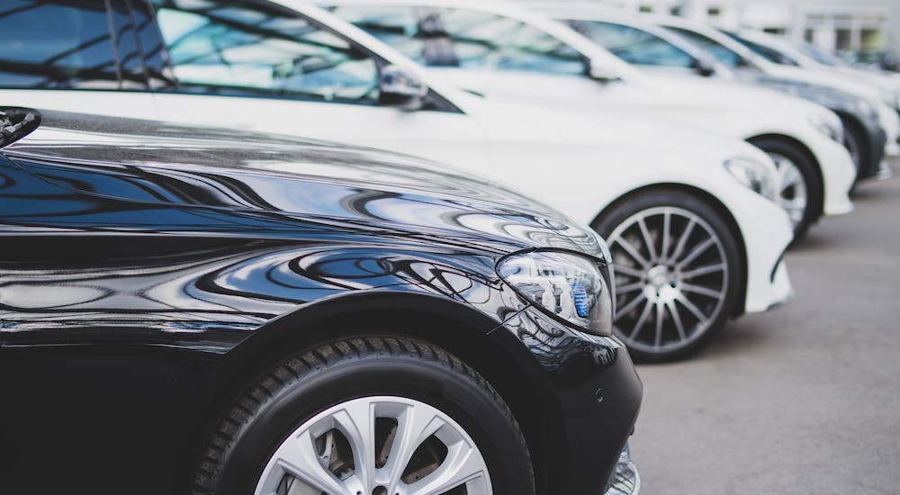 A car dealership shows a row of black and white used cars near you.
