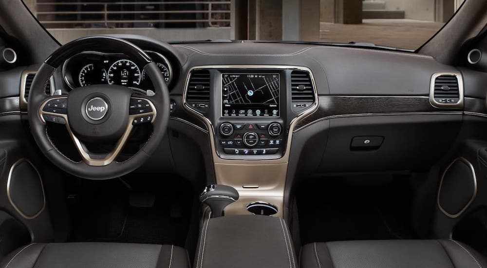 The luxurious black dashboard and steering wheel are shown in a 2011 Jeep Grand Cherokee.