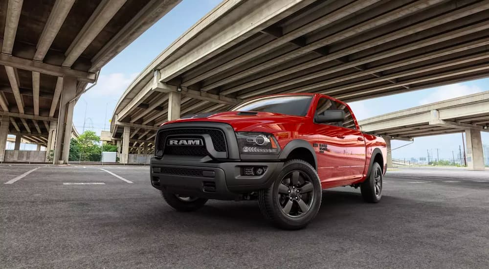 A red 2019 Ram 1500 Warlock is parked under a bridge after leaving a used pickup dealership.