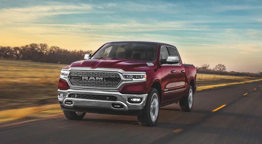 A red 2020 Ram 1500 is driving on an empty highway.