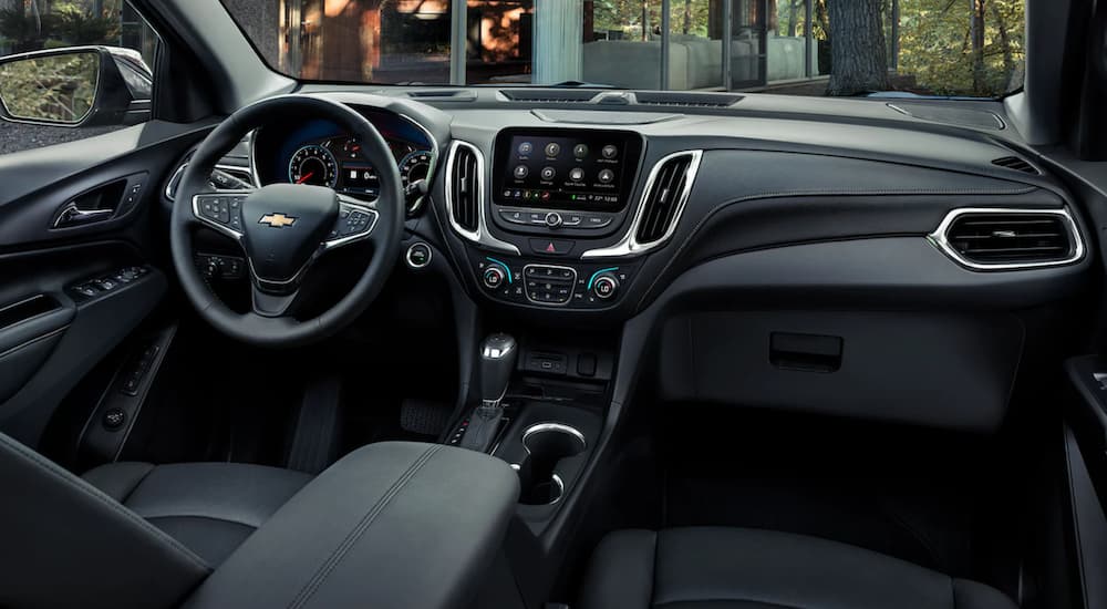 The steering wheel and infotainment screen are shown on the interior of a 2021 Chevy Equinox.