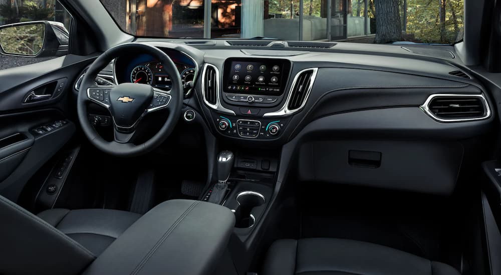 The steering wheel and infotainment screen are shown on the interior of a 2021 Chevy Equinox.