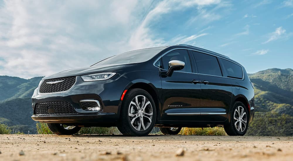 A black 2021 Chrysler Pacifica Pinnacle is shown from a low angle in front of mountains.