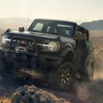 A black 2021 Ford Bronco is off-roading in the desert after winning the 2021 Ford Bronco vs 2021 Jeep Wrangler comparison.