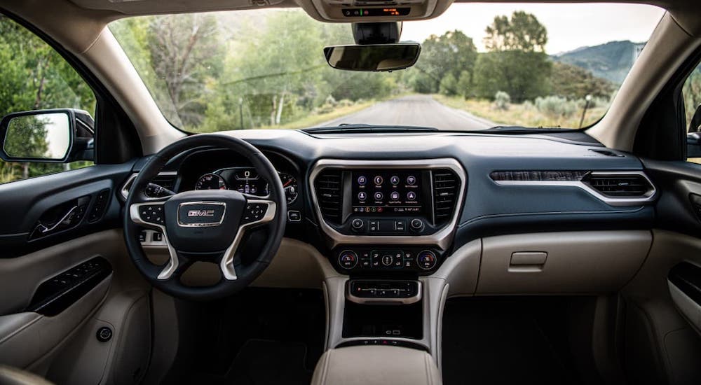 The black and beige dashboard and interior of a 2021 GMC Acadia Denali are shown.