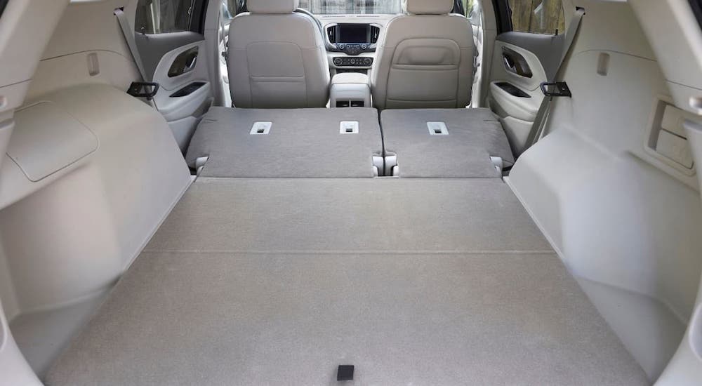 The cargo area is shown in a 2021 GMC Terrain with the rear seats folded down.