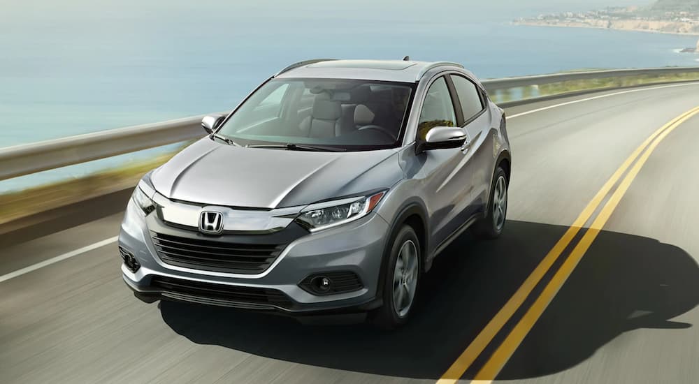 A gray 2021 Honda EX-L is shown from a high angle driving past the ocean.