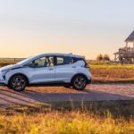 A silver 2022 Chevy Bolt EV is shown from the side parked in front of a beach house.