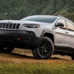 A silver 2019 Certified Pre-Owned Jeep Cherokee is off-roading on a mountain path.