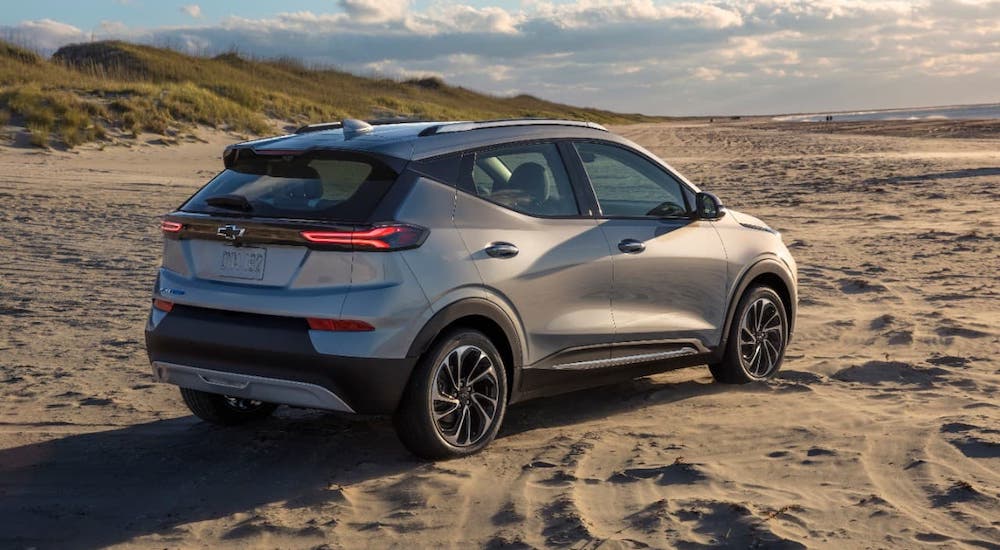 A silver 2022 Chevy Bolt EUV is facing away on a beach.